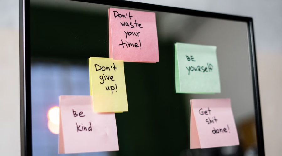 Colorful sticky notes with motivational messages on a mirror reflecting positivity.